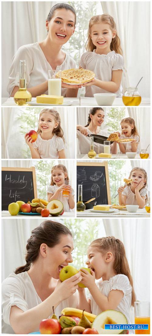 Woman with a little girl, fruit, pancakes - stock photos