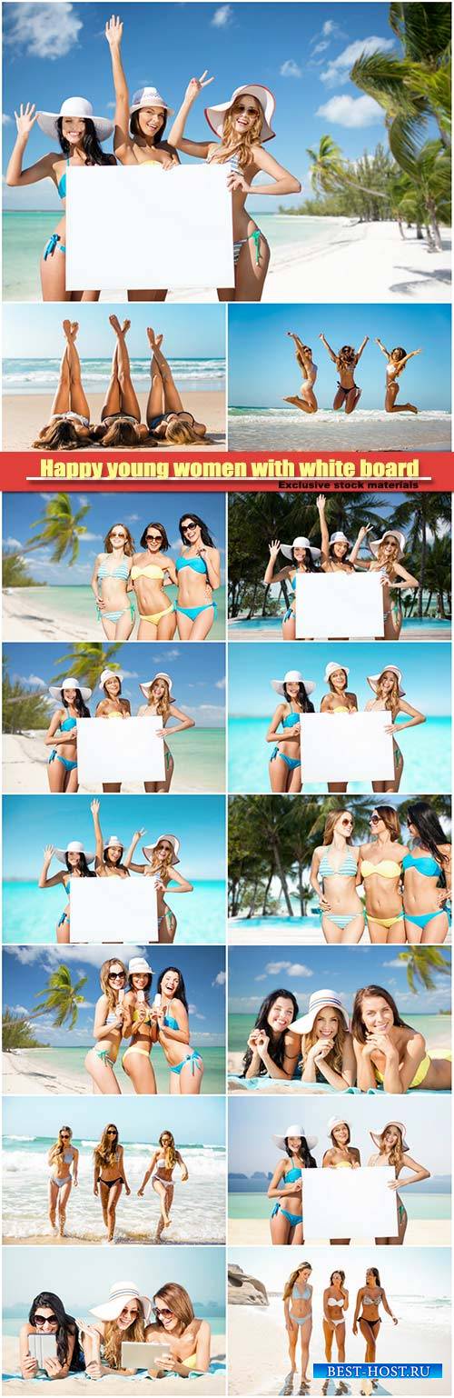 Happy young women with white board on summer beach