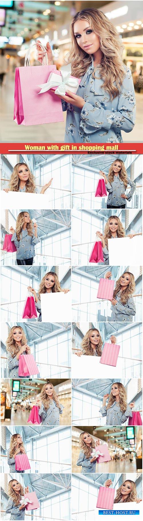 Happy beautiful woman fashion model with gift in shopping mall