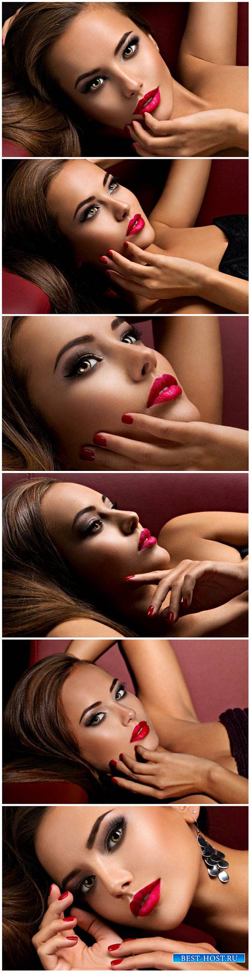 Beautiful woman with bright eye makeup and red lips lying on the sofa